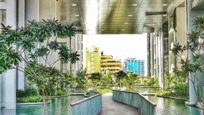 A modern building with a central pathway flanked by water features and greenery. - M city ampang KL by Rit (Kuala Lumpur)