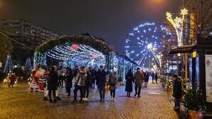 A nighttime street scene with a Ferris wheel, illuminated arches, and a sign reading "Curierul". - Exodus - Iasi City Center (Iași)