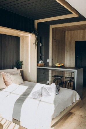 A modern bedroom with a bed, a small kitchenette, and a bar area. - Exodus - Iasi City Center (Iași)