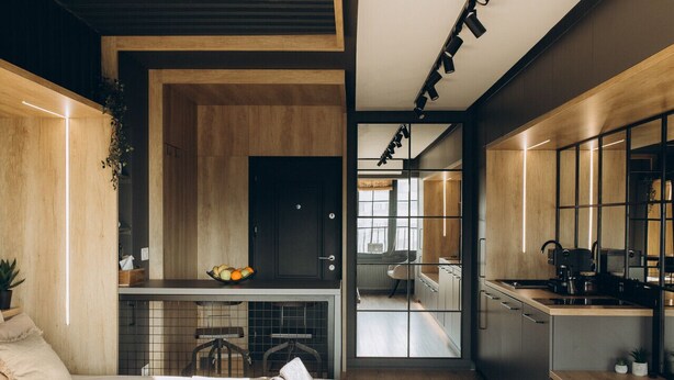 A modern, well-lit bedroom with a large bed, bedside tables, and a view into a connected kitchen and living area. - Exodus - Iasi City Center (Iași)