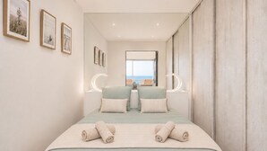 A bedroom with a bed, two bedside tables, a mirror, and framed pictures on the wall. - Rose des Sables • A Terrace Over the Mediterranean (Mauguio)