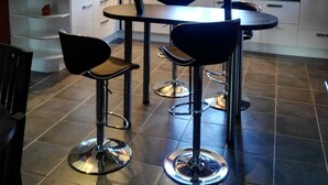 A modern kitchen with a central island, bar stools, and a dining table. - Maison Castellane (Castellane)