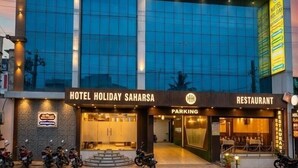 A hotel with a modern glass facade, a restaurant, and a parking area. - Hotel Holiday Saharsa (Saharsa)