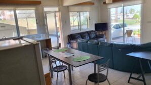 Una cocina moderna con comedor, sofá y televisor.