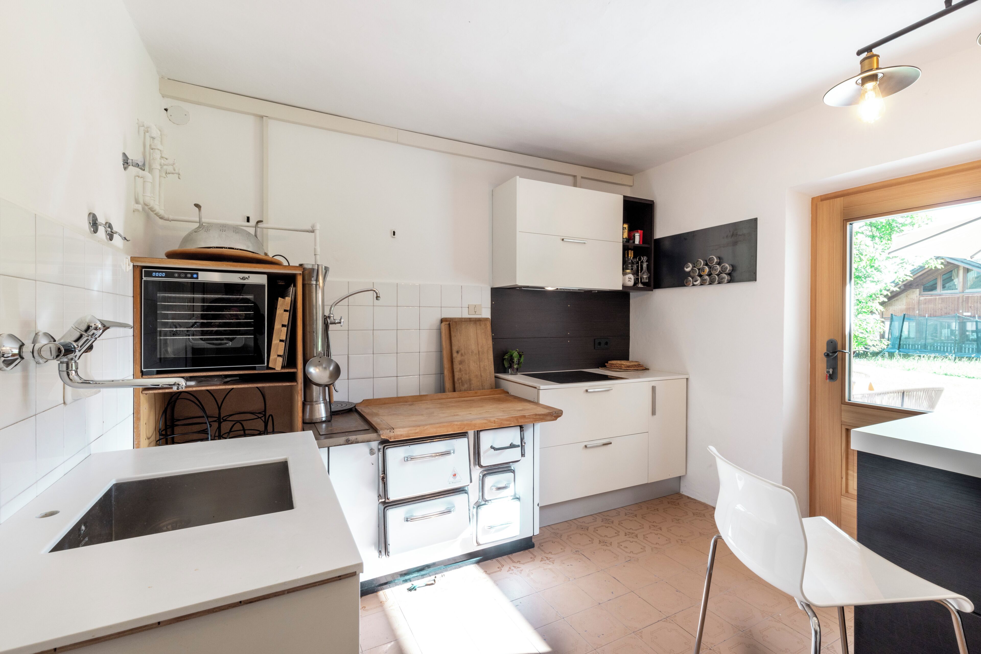 Cocina compacta con lavaplatos, horno y encimera de madera.