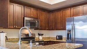 A modern kitchen with granite countertops, stainless steel appliances, and wooden cabinets. - Modern Retreat in Ahwatukee, Heated Pool, Spa, Gym (Phoenix)