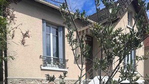 A house with a stone wall, a balcony, and a small garden with artificial grass. - Quiet house between Disneyland and Paris (Villiers-sur-Marne)