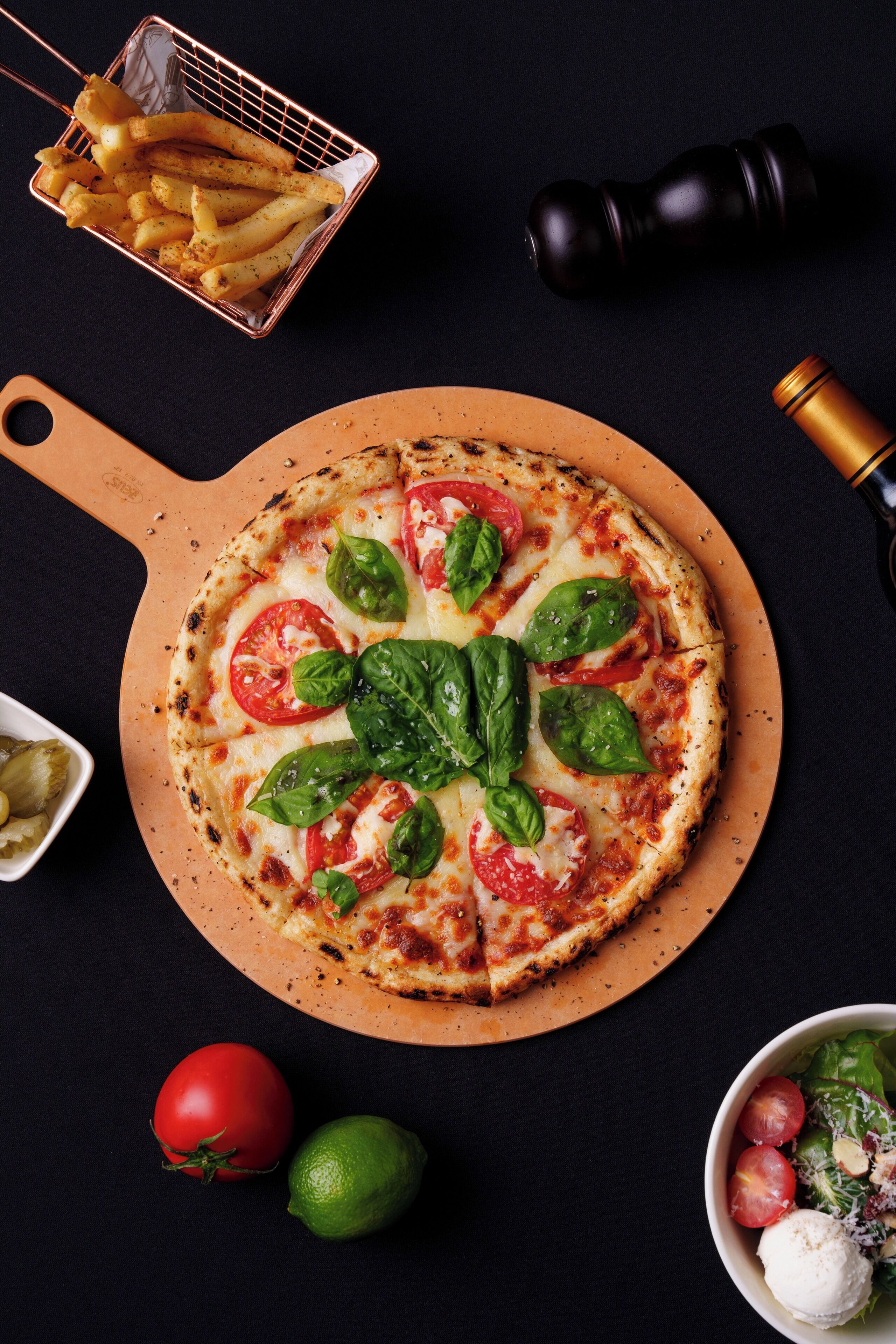 A pizza with tomato and basil toppings on a wooden board.