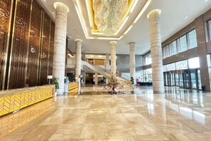 A spacious lobby with a marble floor, a reception desk, a staircase, and a large chandelier. - Royal Hotel (Chongqing Liangjiang) (Chongqing)