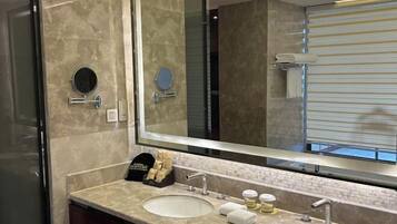 Un baño con dos lavamanos, un espejo grande y un perchero para toallas.