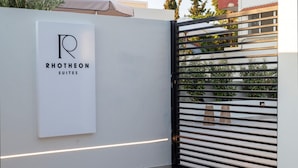 Ein modernes Tor mit einem Schild für RHOTHEON SUITES.