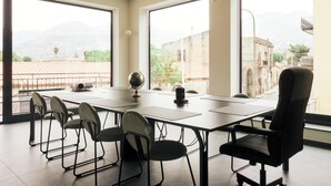 A conference room with a long table, six chairs, and a globe on the table. - HUB Rooms (Carini)