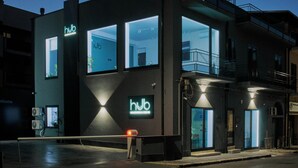 A modern building with 'hub' signage, large windows, and a balcony. - HUB Rooms (Carini)