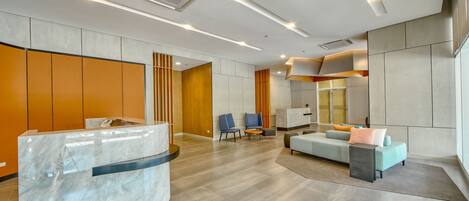 A modern reception area with a marble counter, seating, and a large window.