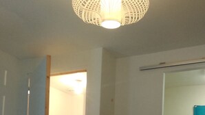 Ein Schlafzimmer mit einem Bett, einem Holzschrank, einem Kleiderschrank und einer Hängeleuchte.