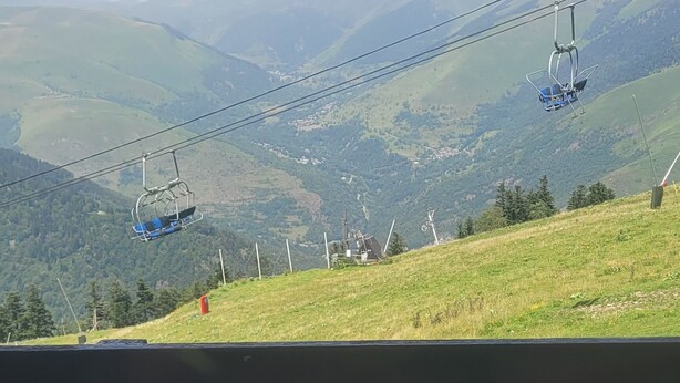 A bench overlooking a mountainous landscape with a cable car in the distance. - Appartement 6 Couchages 1800m d Altitude (Bagnères-de-Luchon)
