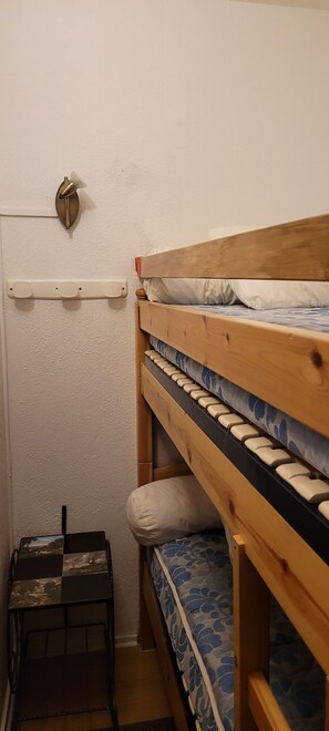 2 dormitorios y tabla de planchar con plancha