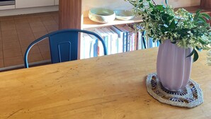 Una cocina moderna con paneles de madera, un lavabo y una zona de comedor con mesa y sillas.