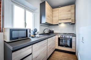Une cuisine moderne équipée d’un four à micro-ondes, d’un évier, d’une cuisinière et d’un four.