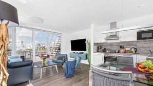 Uma sala de estar moderna com um sofá, mesa de centro e vista para a cidade.
