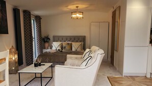 Un salon moderne avec un canapé, une table basse et un lit doté d’une tête de lit.