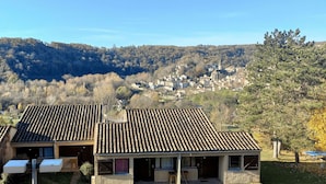Un quartier résidentiel où les maisons sont dotées de toits en tuiles et sont entourées d’une colline boisée.