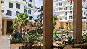 A modern apartment complex with multiple balconies, a swimming pool, and landscaped gardens. - ASTER sea & spa dúplex (Villajoyosa)