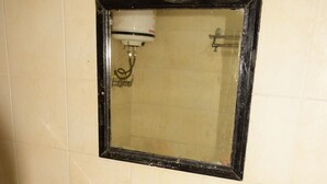 A bathroom with a white sink, two soap dispensers, a mirror, and a shower. - Hotel Ayaan Residency Manali  (Manali)