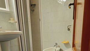 Une salle de bain équipée d’un bidet, de toilettes et d’un lavabo.