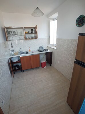 Refrigerador, placa de cocina, utensilios de cocina, mesa de comedor