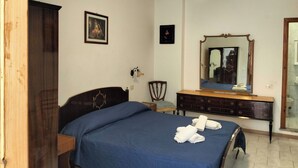 A bedroom with a bed, dresser, mirror, and ceiling fan. - single room with ceiling fan (Lipari)