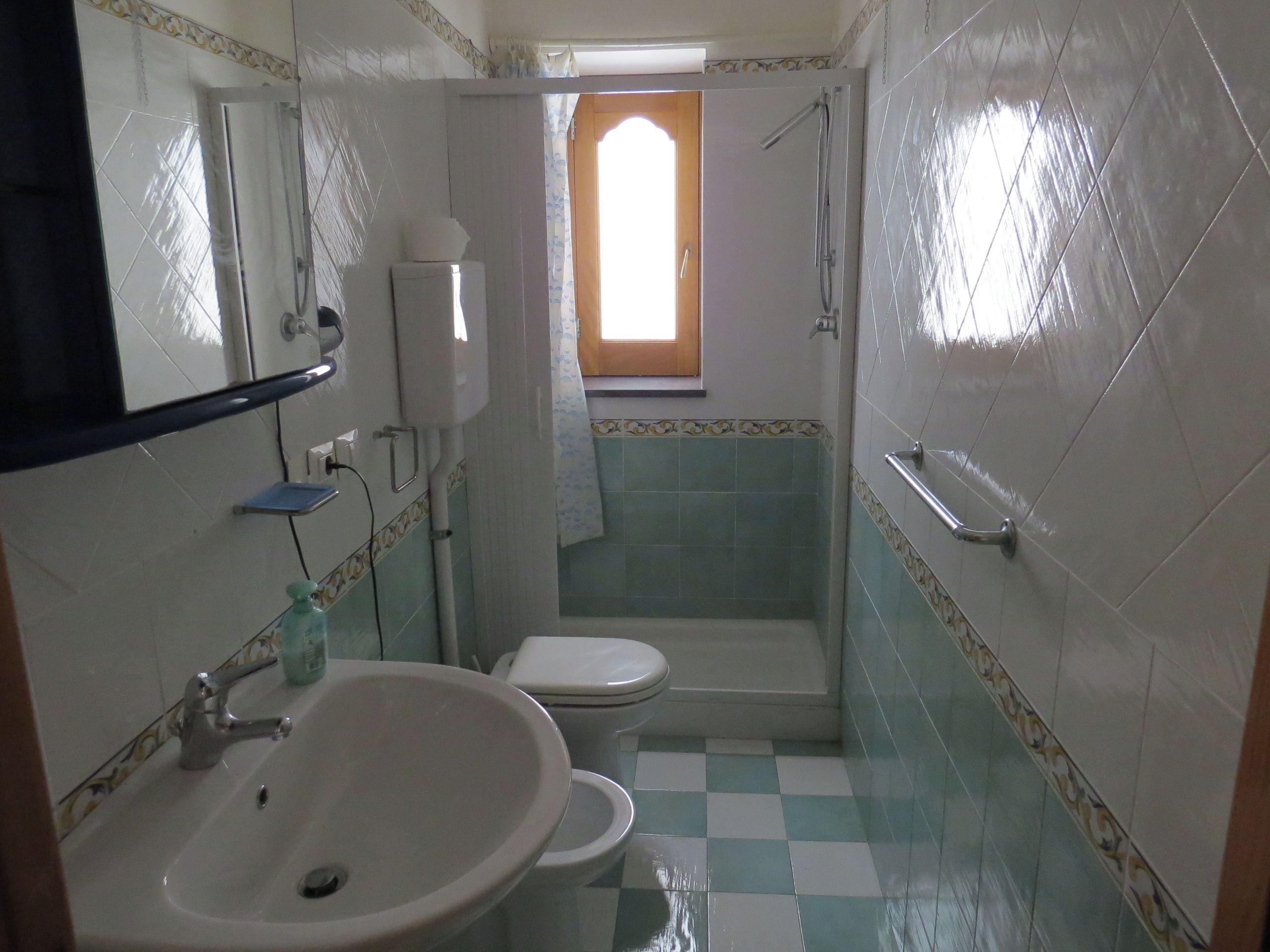 A bathroom with a sink, toilet, and shower.