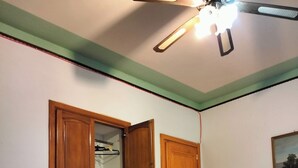 A bedroom with a bed, a chair, a desk with a fan, and two wardrobes. - economy central chamber (Lipari)