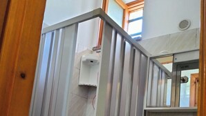 A bathroom with a shower enclosure, a sink, and a mirror. - economy central chamber (Lipari)