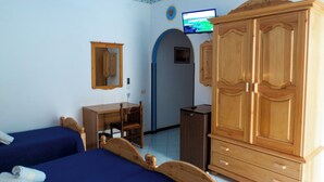 A bedroom with two beds, a wooden wardrobe, a desk, and a television. - Double Comfort (Lipari)