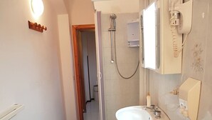 Un baño con ducha, lavamanos e inodoro.