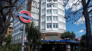 Un panneau indiquant une station du métro londonien, un bâtiment à la façade incurvée et l’entrée de la station de métro de St. John’s Wood.