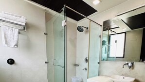 A modern bathroom with a glass-enclosed shower, a white sink, and a toilet. - Qotel Signature Lavish Inn Rajouri Garden (New Delhi)