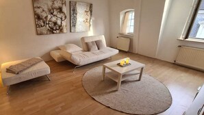 A modern living room with a sofa, a coffee table, and artwork on the wall.