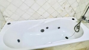 A white bathtub with four drains, a shower head, and a faucet. - Enjoy 1 BR Palm Mar Next to Pool (Arona)