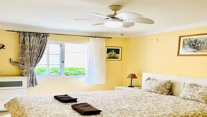 A bedroom with a bed, a ceiling fan, a window with curtains, and a nightstand with a lamp. - Enjoy 1 BR Palm Mar Next to Pool (Arona)