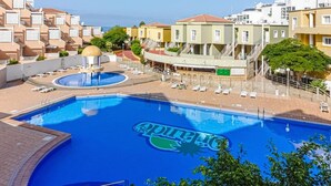 A swimming pool with a logo, surrounded by buildings and a clear sky.