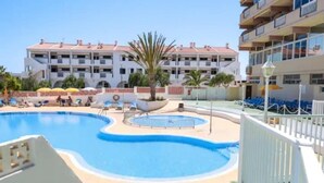 A hotel pool area with sun loungers and a palm tree. - Central 2bedroom 200m From Beach (Adeje)