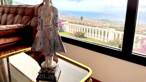 A statue on a glass table with a view of a cityscape through a window. - Villa in La Orotava 7 Bedrooms 1 bed 7 Baths (La Orotava)