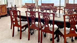 A spacious dining area with a large table and ornate chairs, a chandelier, and a view of the sea through large windows. - Villa in La Orotava 7 Bedrooms 1 bed 7 Baths (La Orotava)