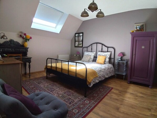 Ein Schlafzimmer mit Bett, Schreibtisch, Stuhl, Kleiderschrank, Heizkörper, Fenster und Deckenleuchte.