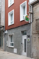 Un edificio con fachada de ladrillo rojo, ventanas blancas y un letrero que indica que es un hotel de calidad.