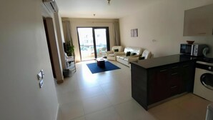 Eine moderne Wohnung mit Wohnzimmer, Küche und Balkon.