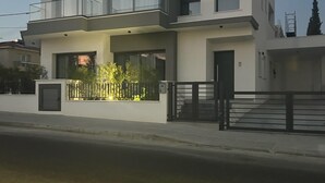 A modern two-story house with a balcony, a gated entrance, and a well-maintained garden. - Cozy 3 Bedroom Villa Close to the Beach (Limassol)