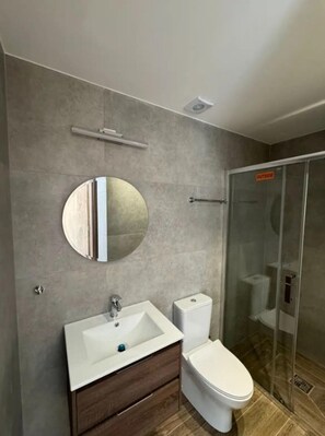 Villa | Badkamer | Een douche, een haardroger, handdoeken